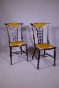 A pair of Art Nouveau stained beechwood side chairs with carved and pierced backs, raised on