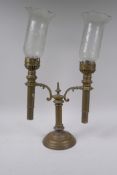 An antique brass two branch candle stick with glass storm shades, glass AF, faults, 32cm high