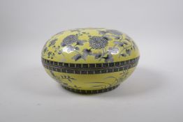 A Chinese yellow ground porcelain box and cover with black and white floral decoration, seal mark to