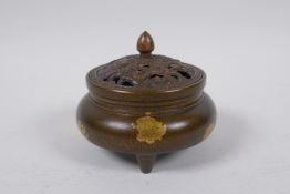 A Chinese bronze censer and cover on tripod supports, with a pierced cover decorated with water foul