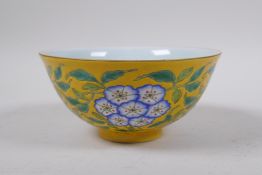 A polychrome porcelain rice bowl with enamelled floral decoration on a yellow ground, Chinese KangXi