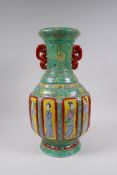 A green ground porcelain two handled vase with yellow decorative panels depicting women of