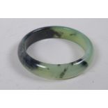 A Chinese mottled green and black jade bangle, 8cm diameter