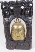 A Chinese brass temple gong in a carved hardwood stand, 37cm high