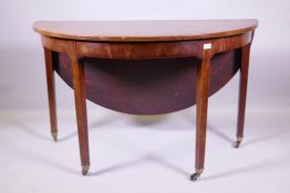 A Georgian mahogany demi lune table with fold over top, raised on square tapering supports with