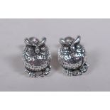 A pair of silver stud earrings in the form of owls