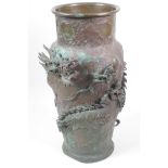 A Japanese Meiji period bronze vase decorated with an entwined dragon, the base with embossed floral