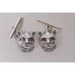 A pair of sterling silver cats head cufflinks, with ruby eyes
