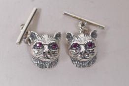 A pair of sterling silver cats head cufflinks, with ruby eyes