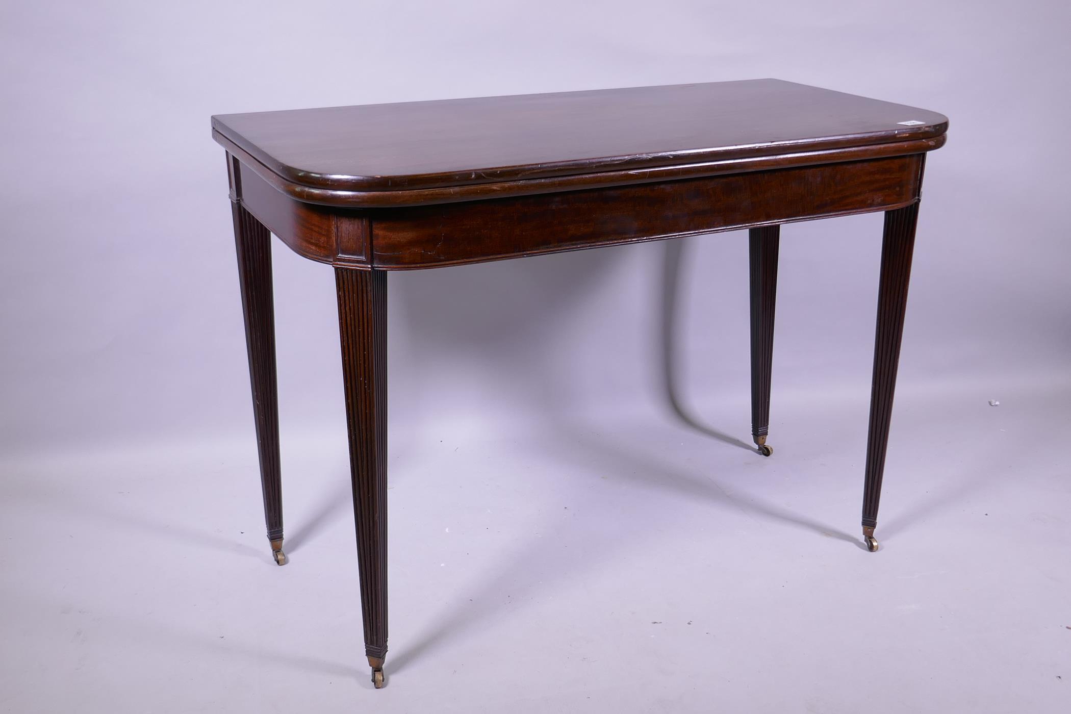 A Georgian mahogany D shaped tea table, raised on tapering reeded supports with brass castors, 102 x - Image 2 of 6