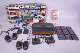 A vintage Atari CX-2600 video computer system home video console with various controllers, driving