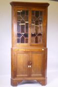 A C19th oak standing corner cupboard with astragal glazed upper section and shaped front shelves