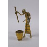 An African Benin style brass figure of a mother carrying a child and using a pestle and mortar, 13cm