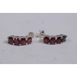 A pair of silver and garnet set earrings