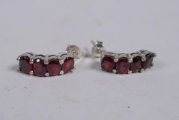 A pair of silver and garnet set earrings