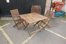 Four stacking teak garden chairs and a table