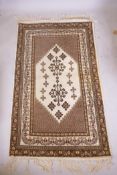 A Tunisian cream ground geometric rug with brown borders, 118cm x 190cm, and a cream ground Kashmiri
