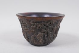 A Chinese faux horn bowl with carved decoration of figures in a landscape, 12cm diameter