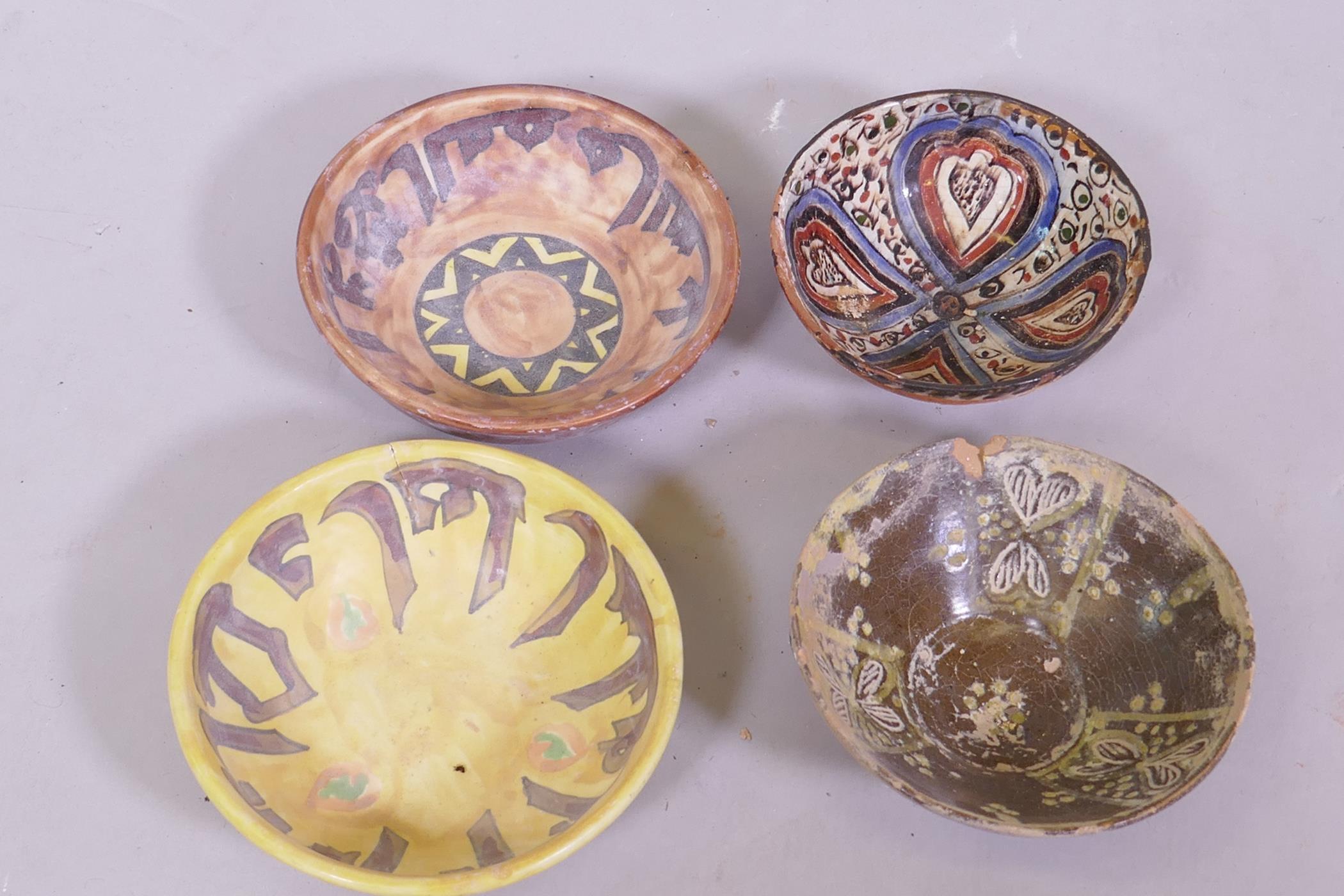 Four terracotta bowls with Islamic decoration and calligraphy, 15cm diameter