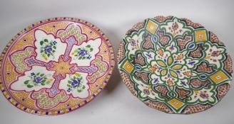 Two large African earthenware pottery shallow bowls brightly painted in geometric patterns, 41cm
