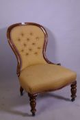 A Victorian walnut balloon back nursing chair with button back upholstery, raised on turned supports