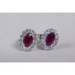 A pair of 18ct white gold oval shaped ruby and diamond set ear studs, approx 1ct totoal