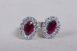 A pair of 18ct white gold oval shaped ruby and diamond set ear studs, approx 1ct totoal