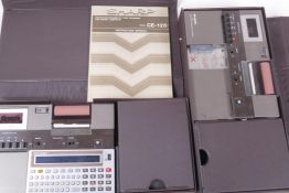 A vintage Sharp CE-125 pocket computer, boxed, with printer and mini tape recorder, comes with