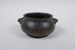 A Chinese bronze censer with two lion mask handles, impressed character marks to base, 10cm diameter