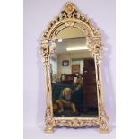 A gilt wall mirror with carved and pierced decoration, 70 x 140cm