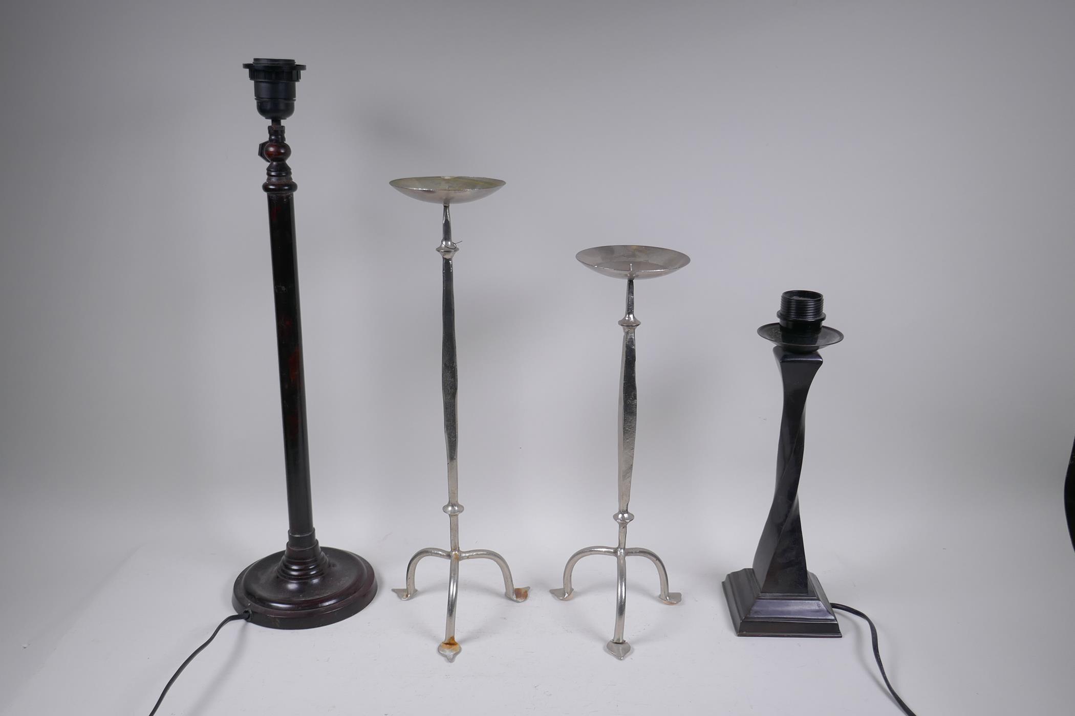 A plated pricket candle stick and another, smaller, together with two bronze table lamps, largest