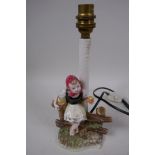 An Austrian Belvedere pottery table lamp modelled as a young girl sitting on a fence, 28cm high
