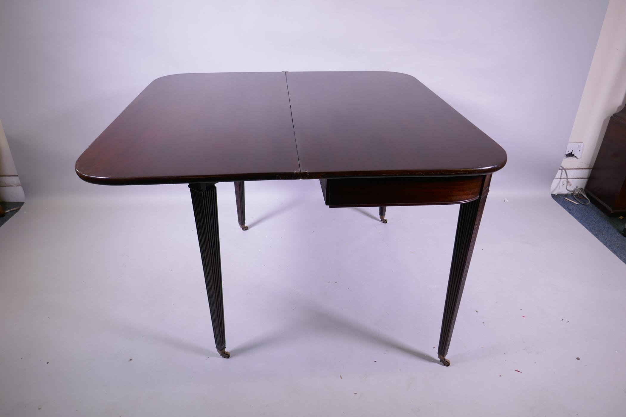 A Georgian mahogany D shaped tea table, raised on tapering reeded supports with brass castors, 102 x - Image 4 of 6