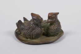 A Japanese bronze okimono of two waterfowl on a lily pond, 8cm diameter