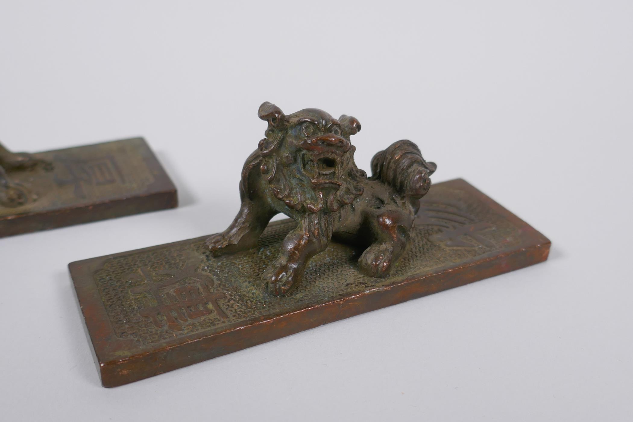 A pair of Chinese bronze scroll weights with kylin mounts, character marks to base, 11cm long - Image 2 of 4