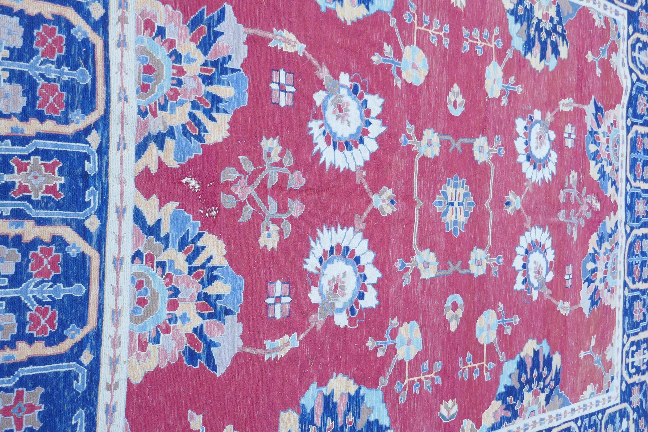 A Middle Eastern hand woven wool carpet with stylised floral designs on a faded red field, 320 x - Image 5 of 9