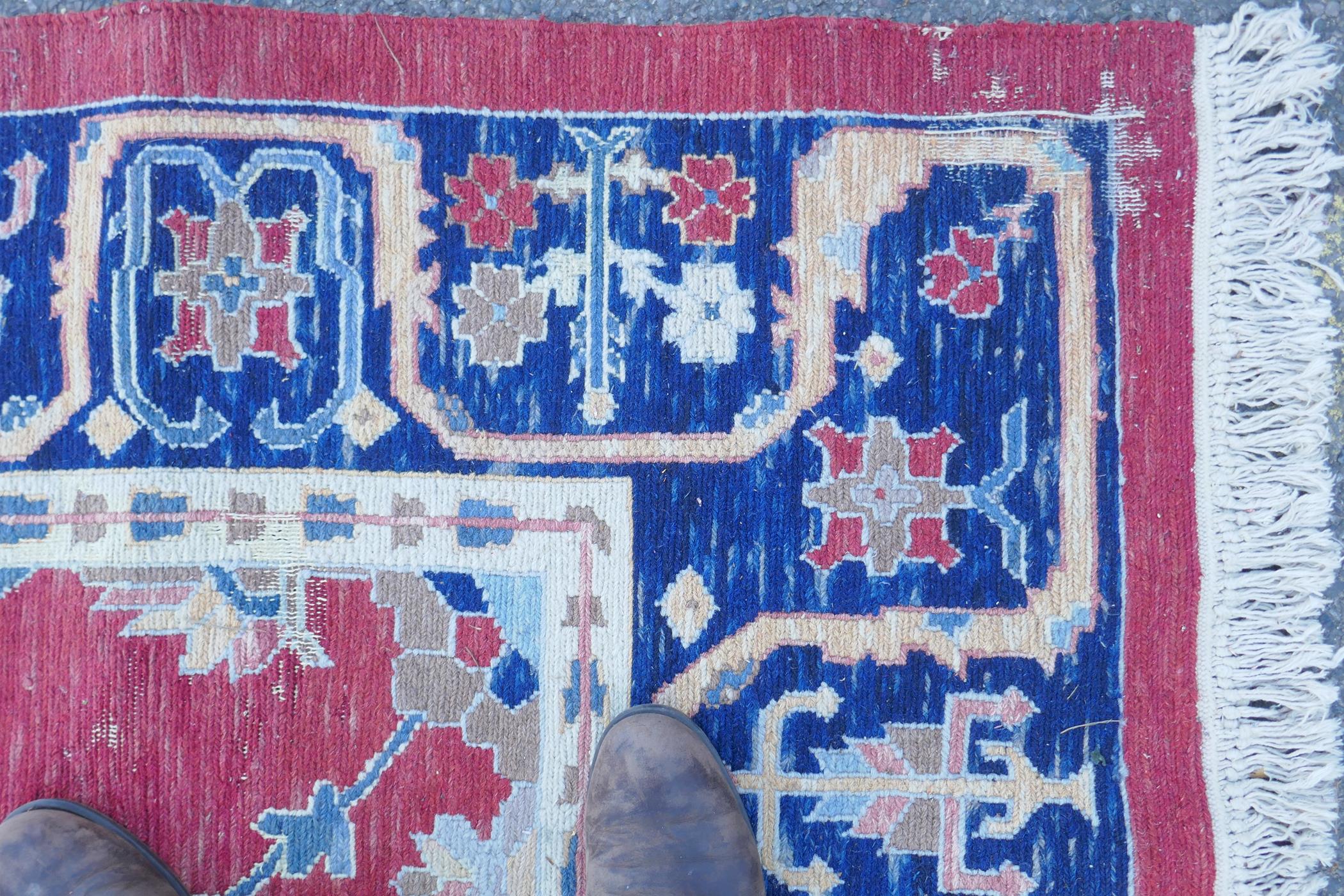 A Middle Eastern hand woven wool carpet with stylised floral designs on a faded red field, 320 x - Image 9 of 9