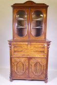 A C19th continental flame mahogany secretaire bookcase, the upper section with two glazed doors over