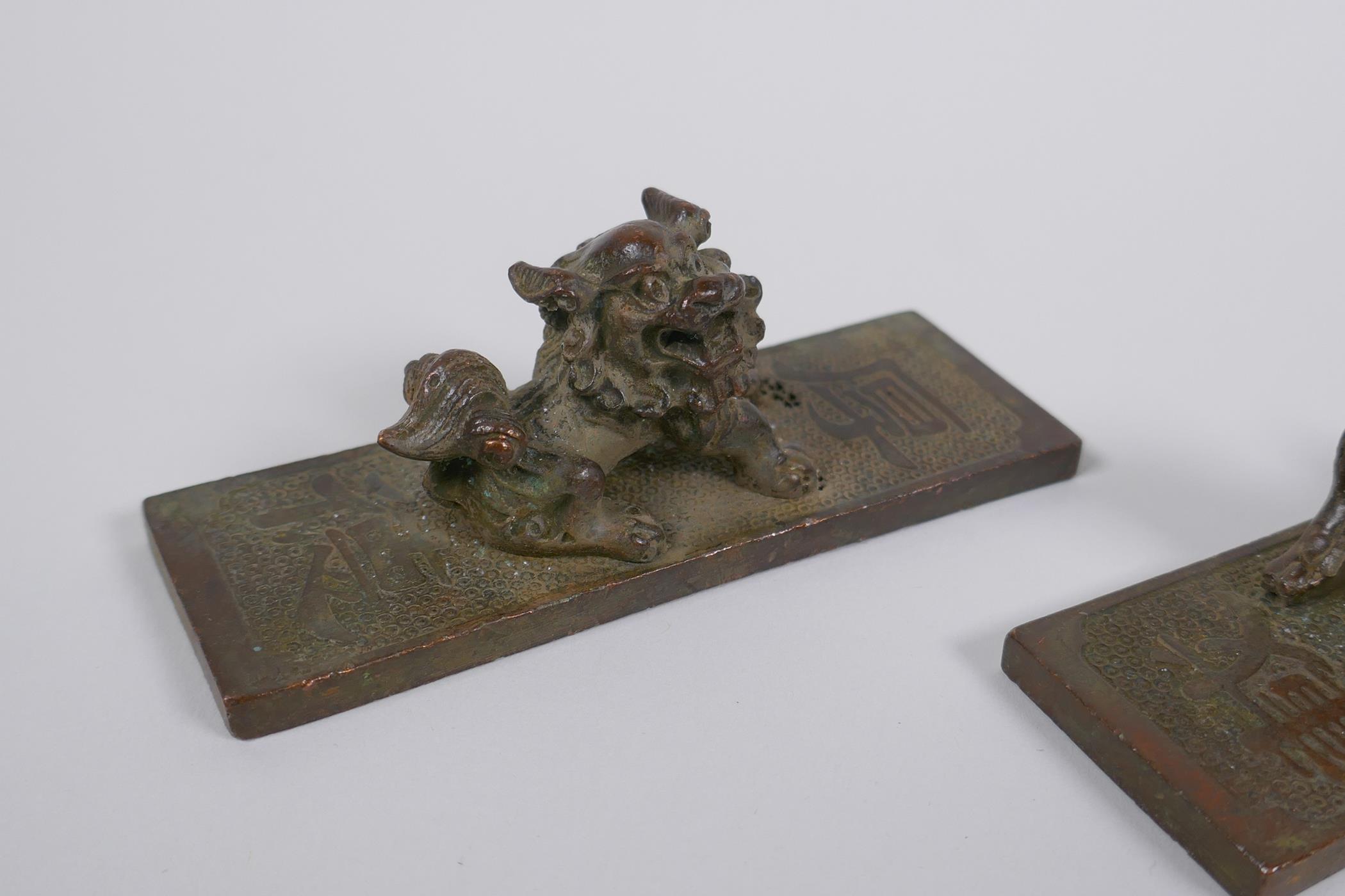 A pair of Chinese bronze scroll weights with kylin mounts, character marks to base, 11cm long - Image 3 of 4