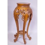 A Chinese jardiniere stand with carved and pierced details, raised on shaped supports with scroll