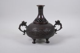 A Chinese bronze two handled censer and cover raised on tripod supports, with bat, dragon and