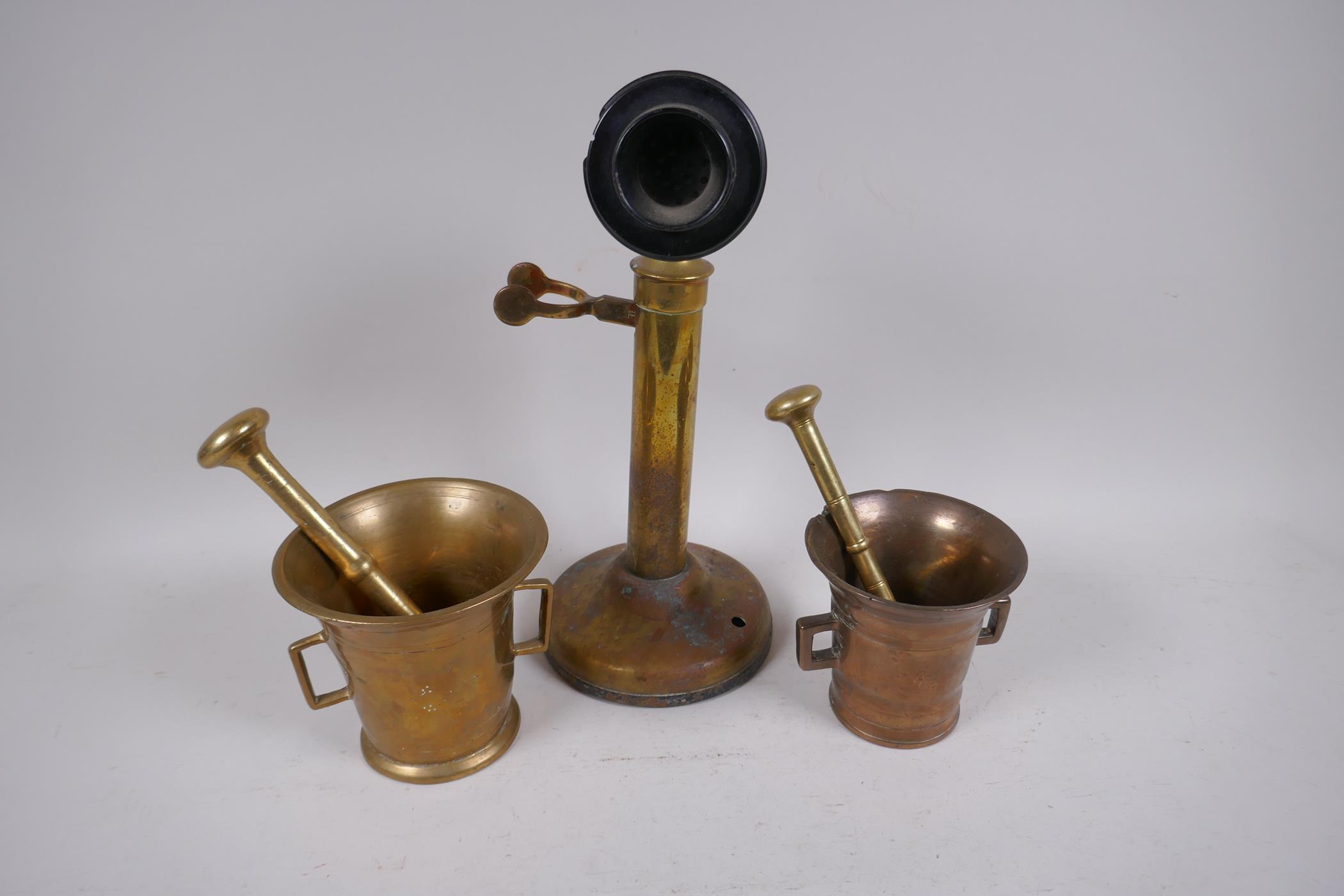 A brass candlestick telephone, AF, 31.5cm high, and two brass mortar and pestles