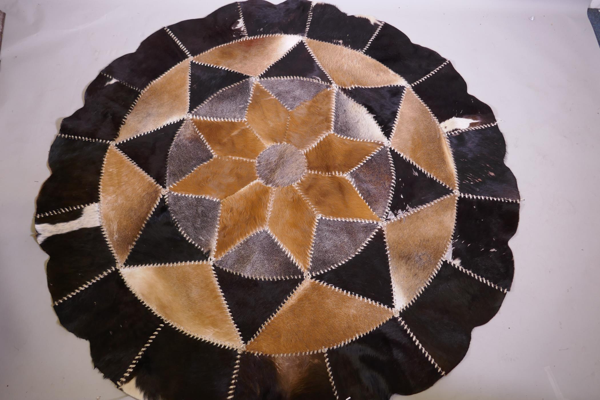 A patchwork cowhide rug, 175cm diameter