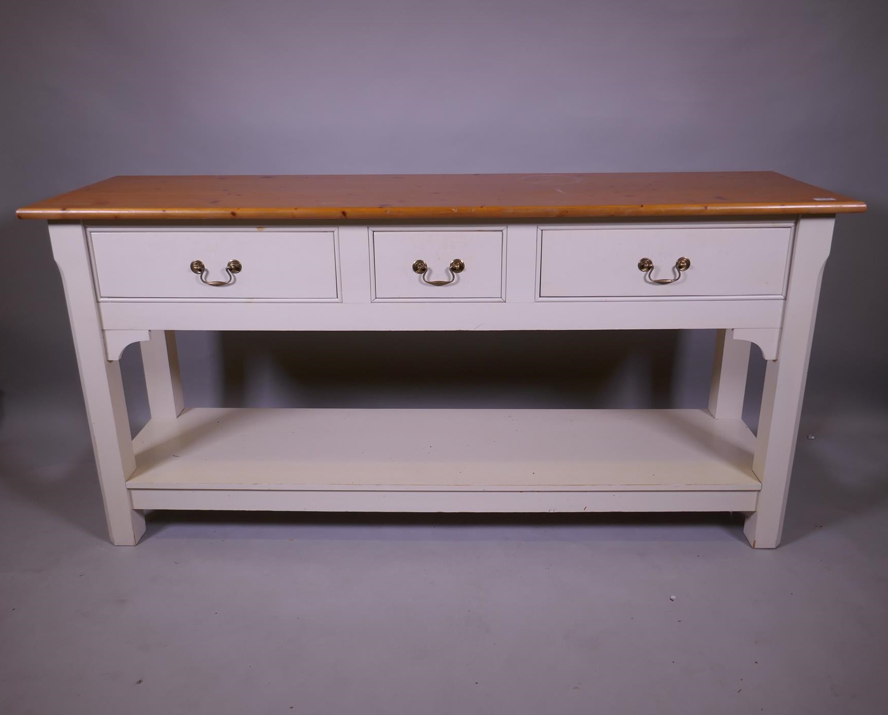 A contemporary pine dresser, the painted base with two drawers and pot board, raised on chamfered