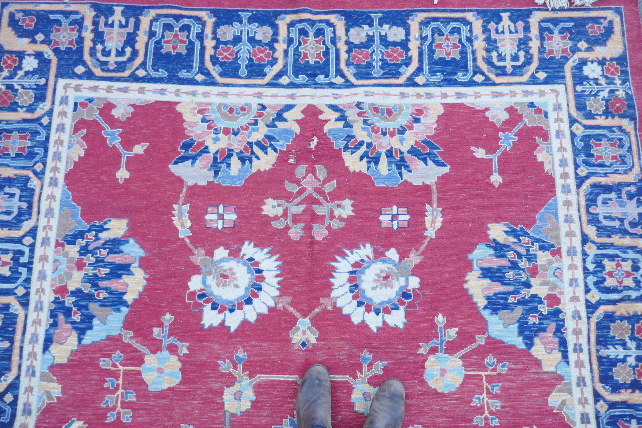 A Middle Eastern hand woven wool carpet with stylised floral designs on a faded red field, 320 x - Image 4 of 9