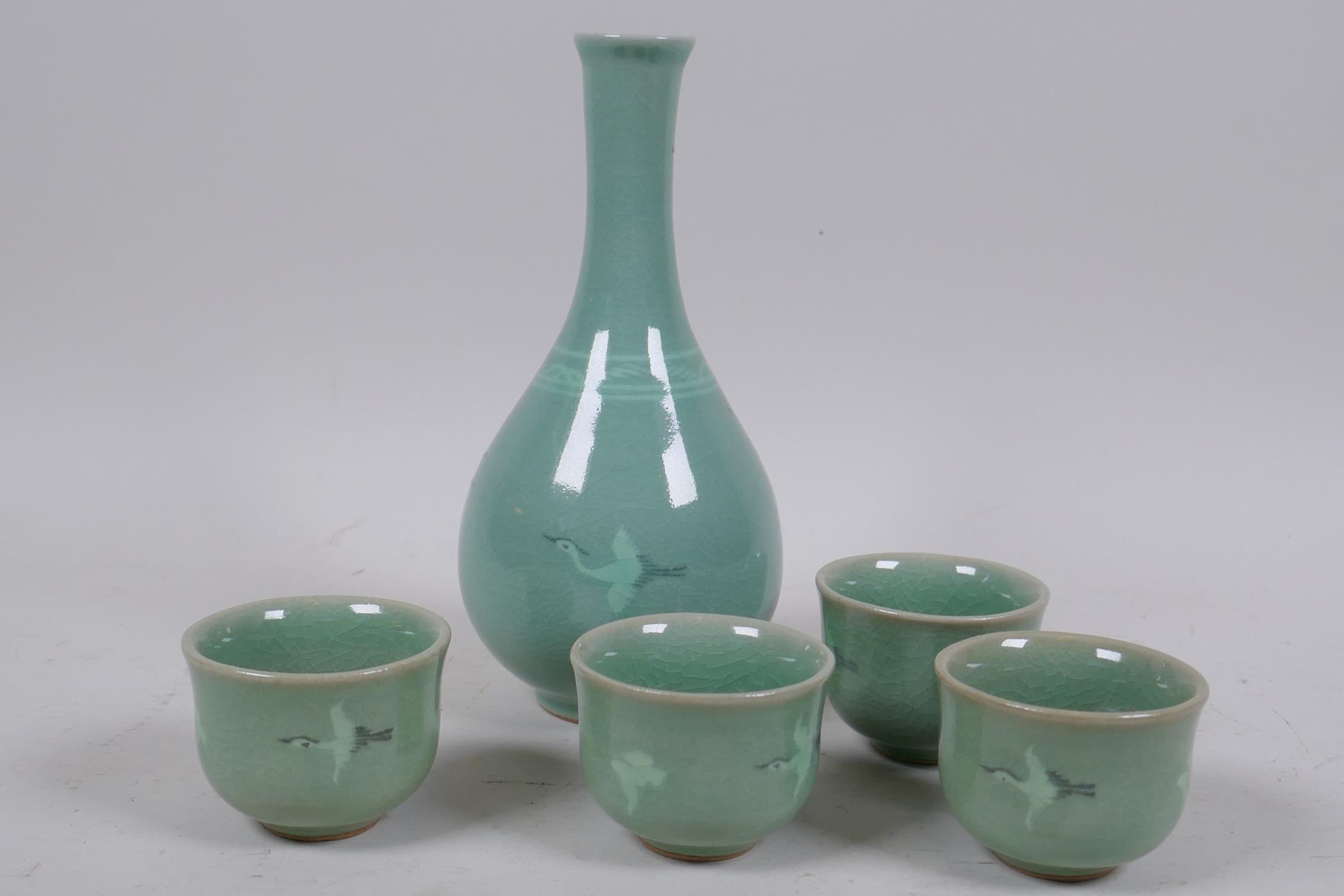 Oriental celadon glazed wine bottle and four cups, decorated with flying birds, 17cm high