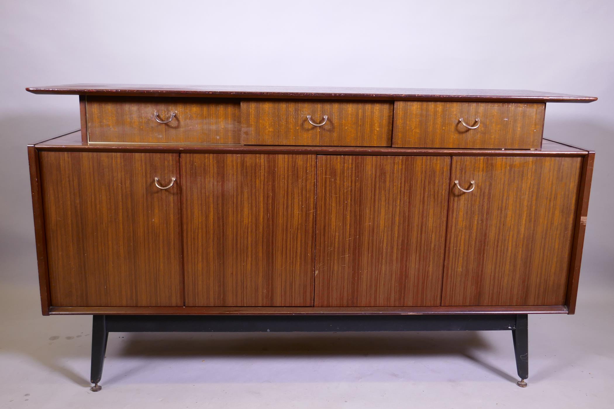 A mid century G-Plan Librenza tola sideboard raised on ebonised supports, 150 x 46 x 86cm