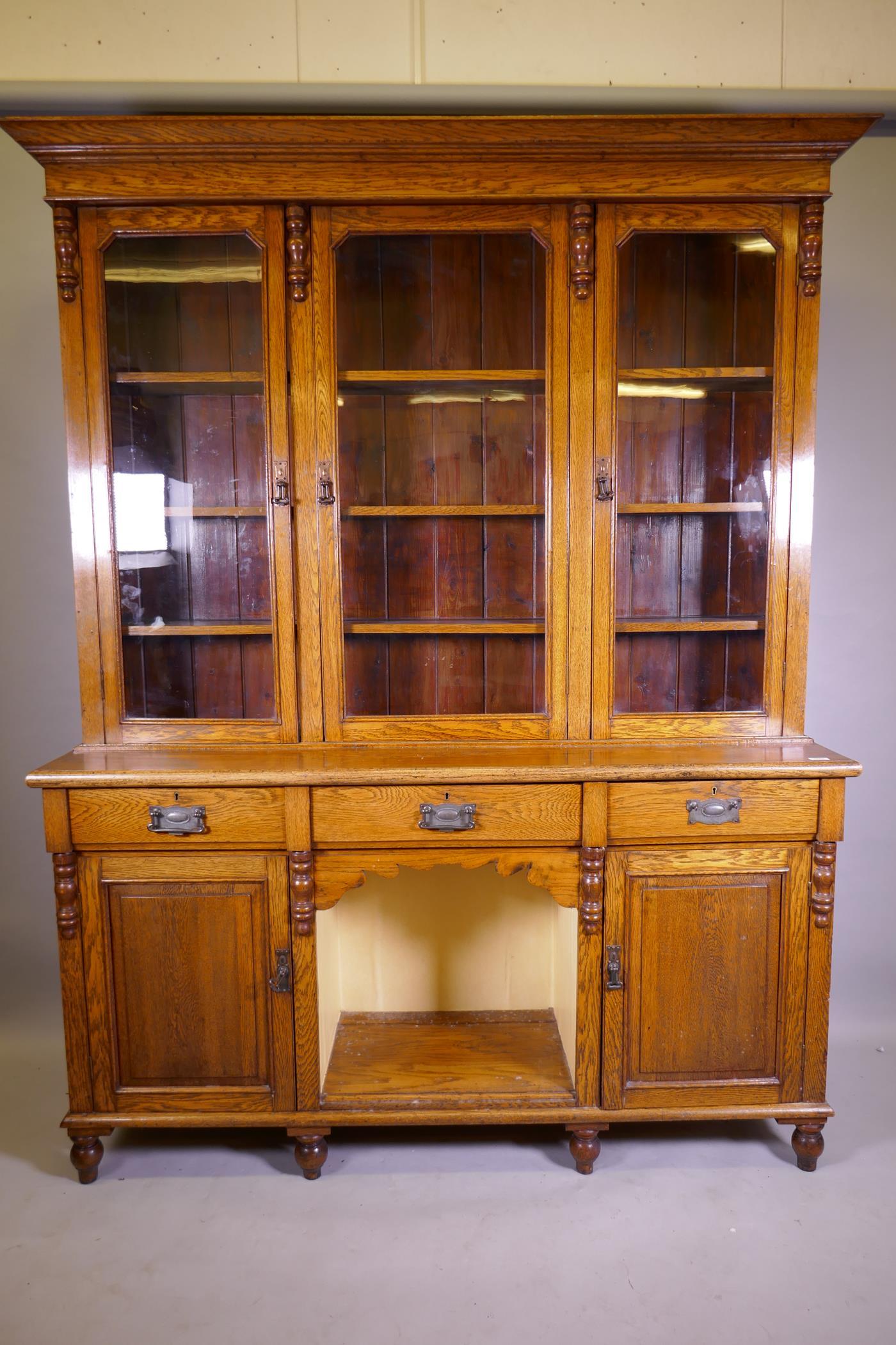 A C19th oak dresser, the upper section with three glazed doors, the base with three drawers over two
