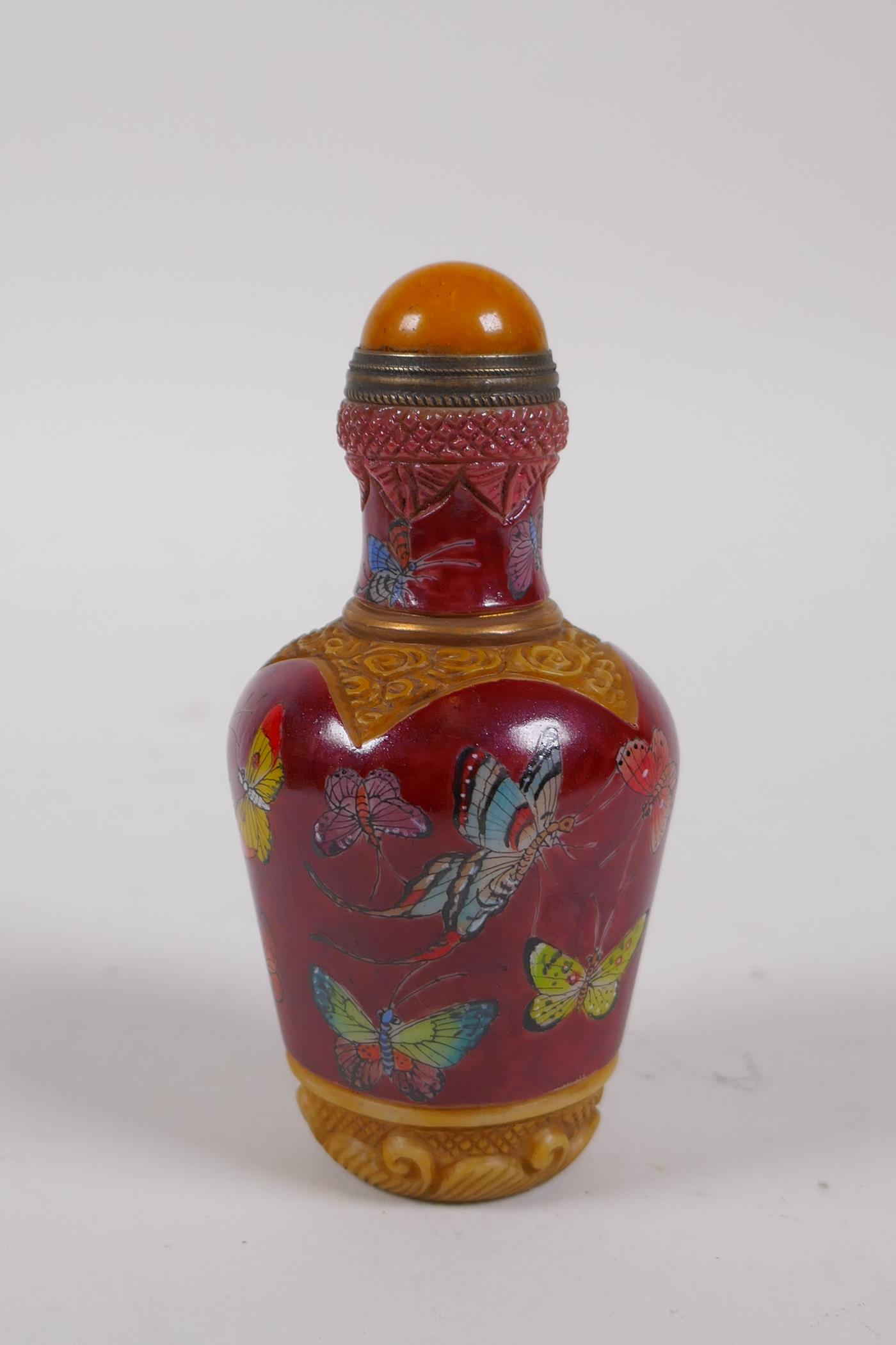 A Chinese moulded glass snuff bottle with enamelled butterfly decoration, 4 character mark to