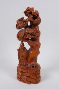 A Chinese carved boxwood ornament depicting a sage standing under a tree, 22cm high